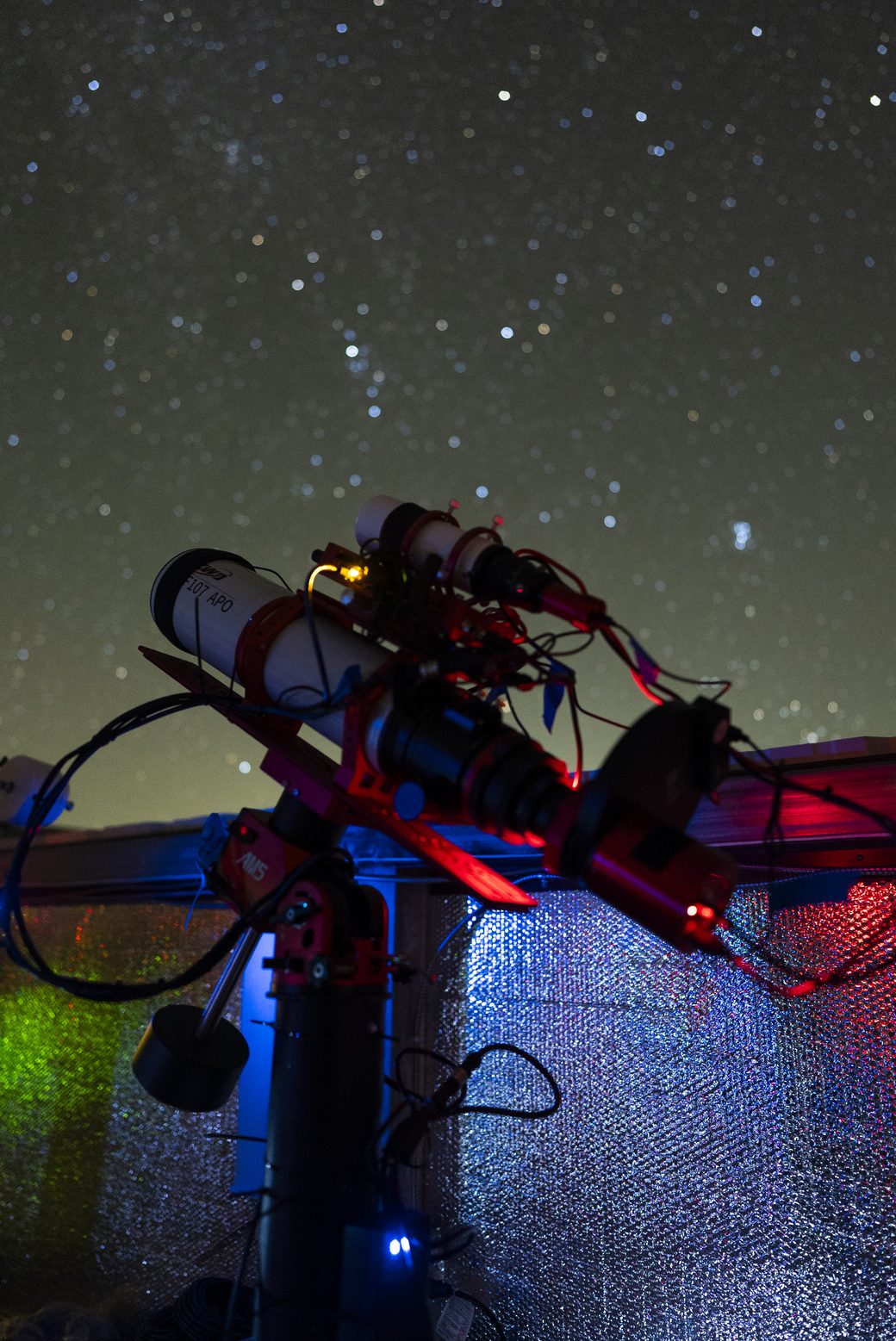 The imaging rig at Starfront under a starry night sky, telescope angled upward